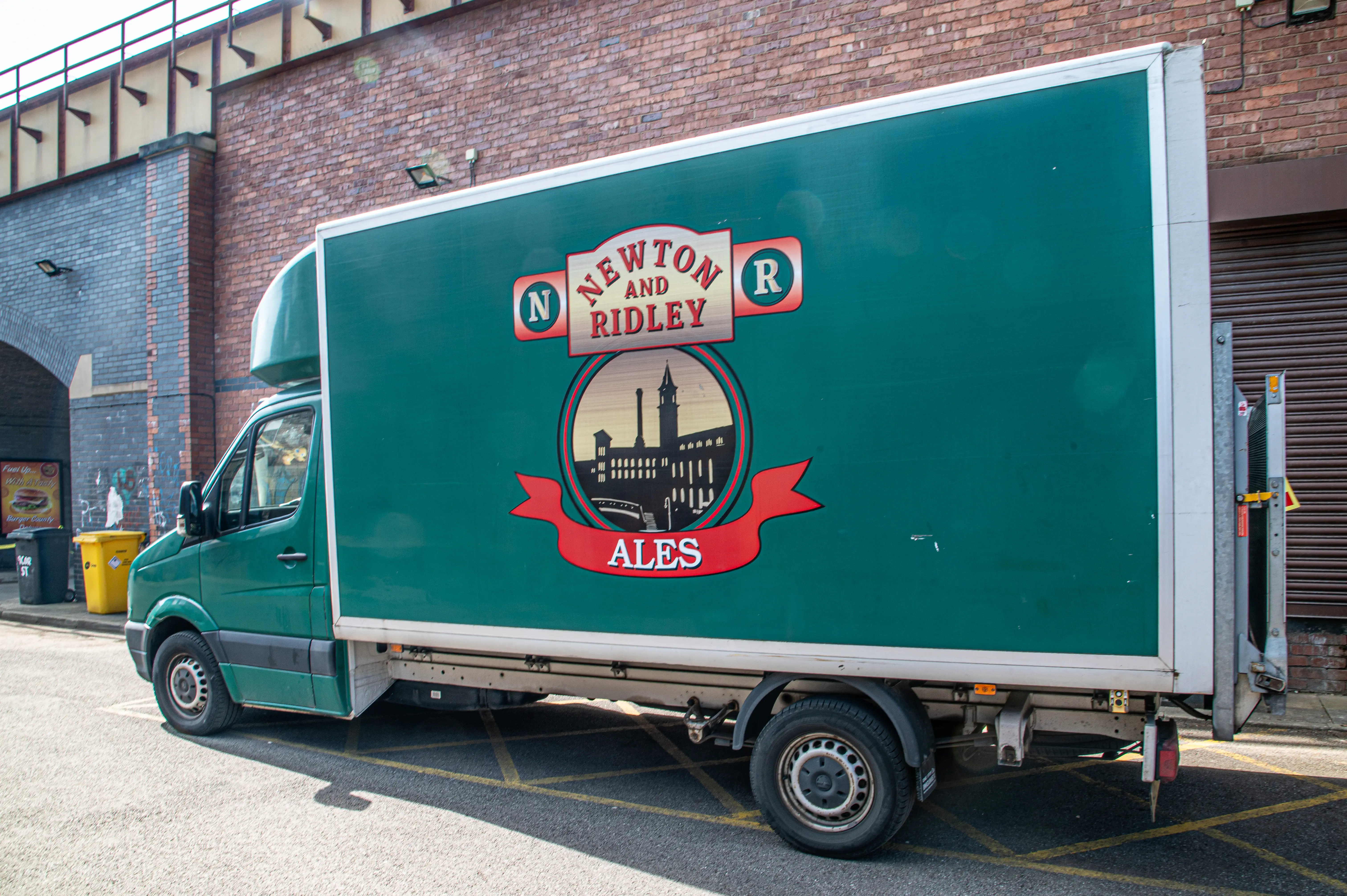 A green delivery van with the Newton & Ridley Ales logo parked on a street.