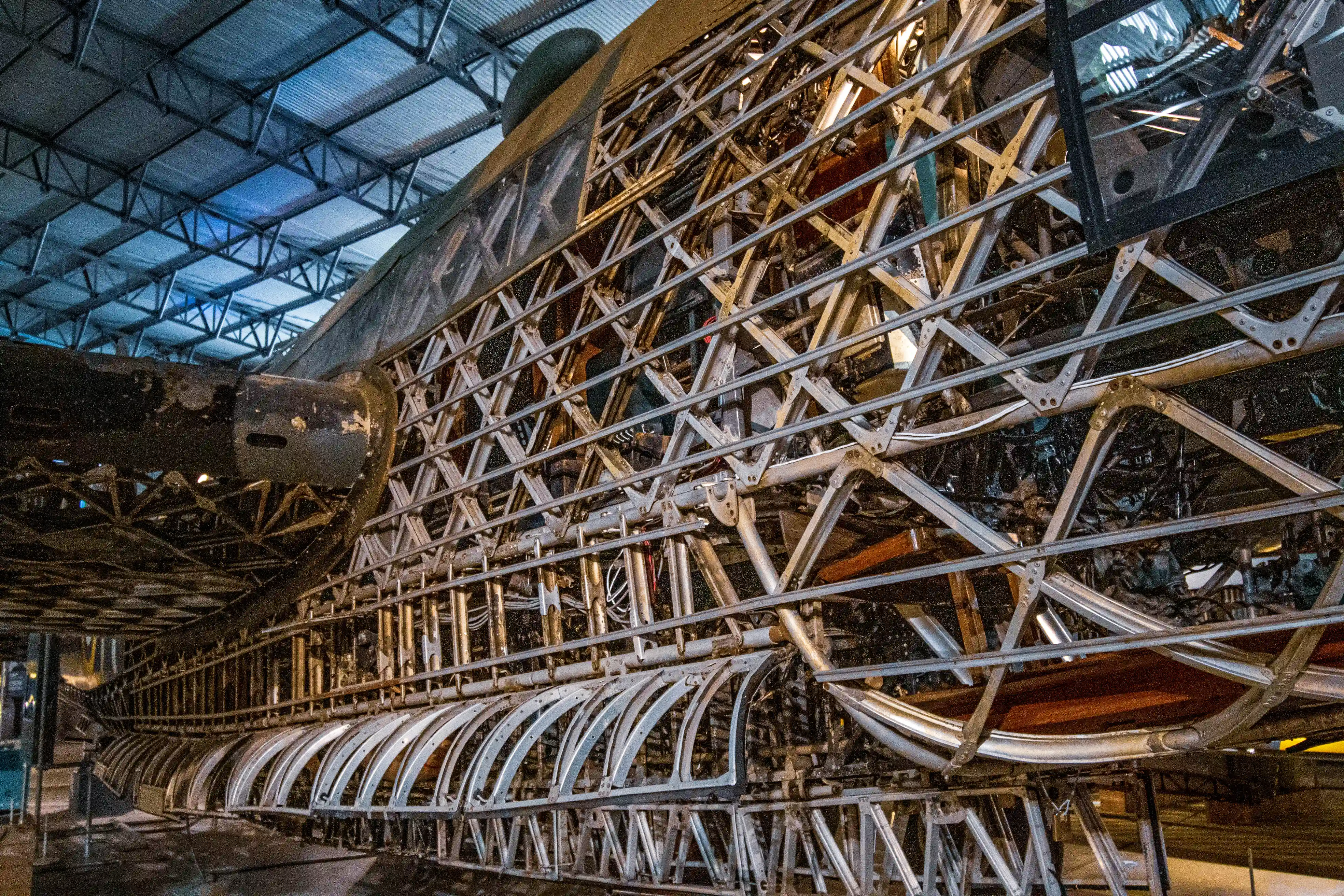 Close-up view of the metallic lattice structure and internal components of an aircraft fuselage, viewed from the side.