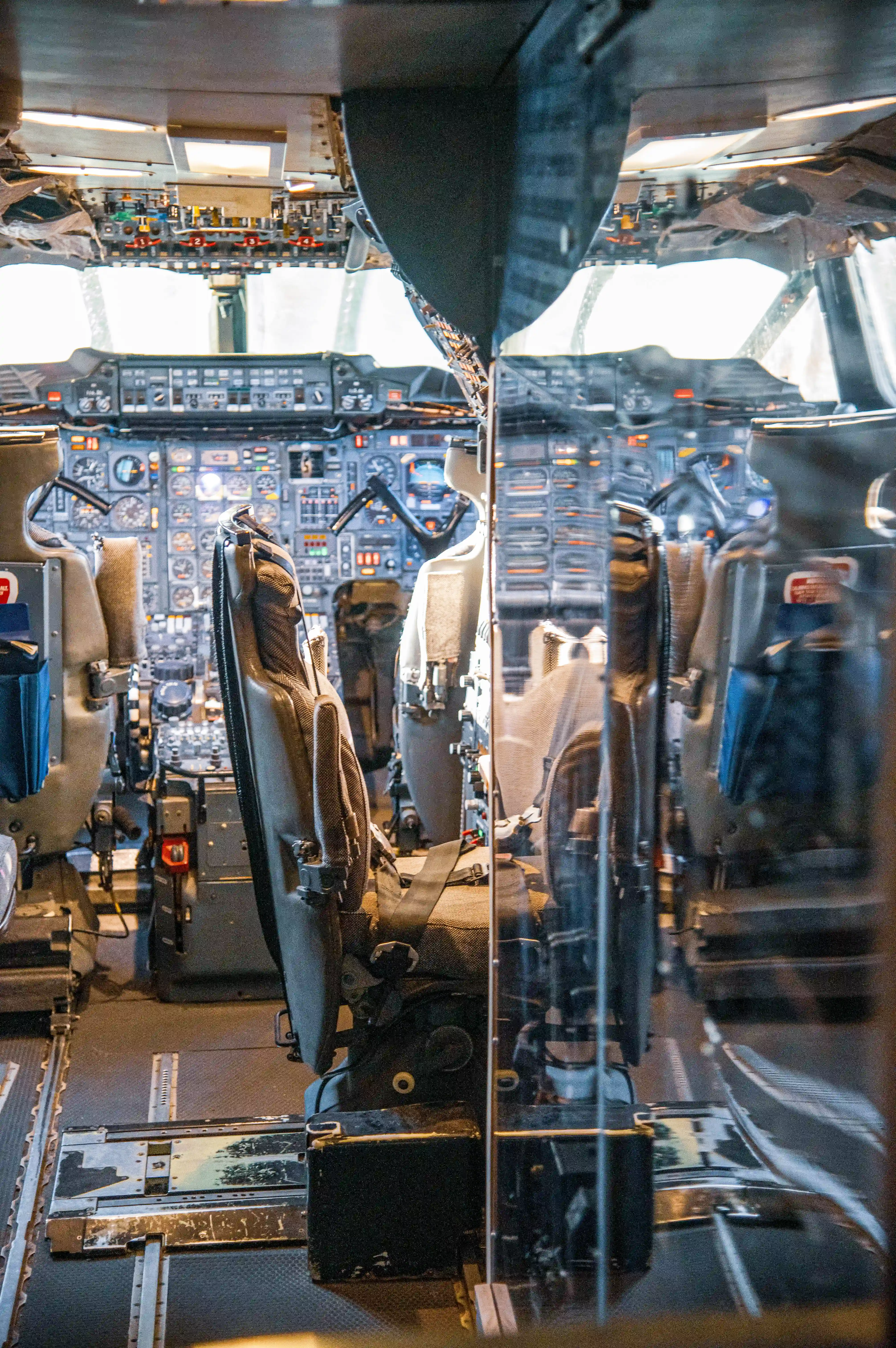 Interior view of a Concorde supersonic jet cockpit, showing pilot and co-pilot seats, numerous gauges, switches, and controls on the dashboard.
