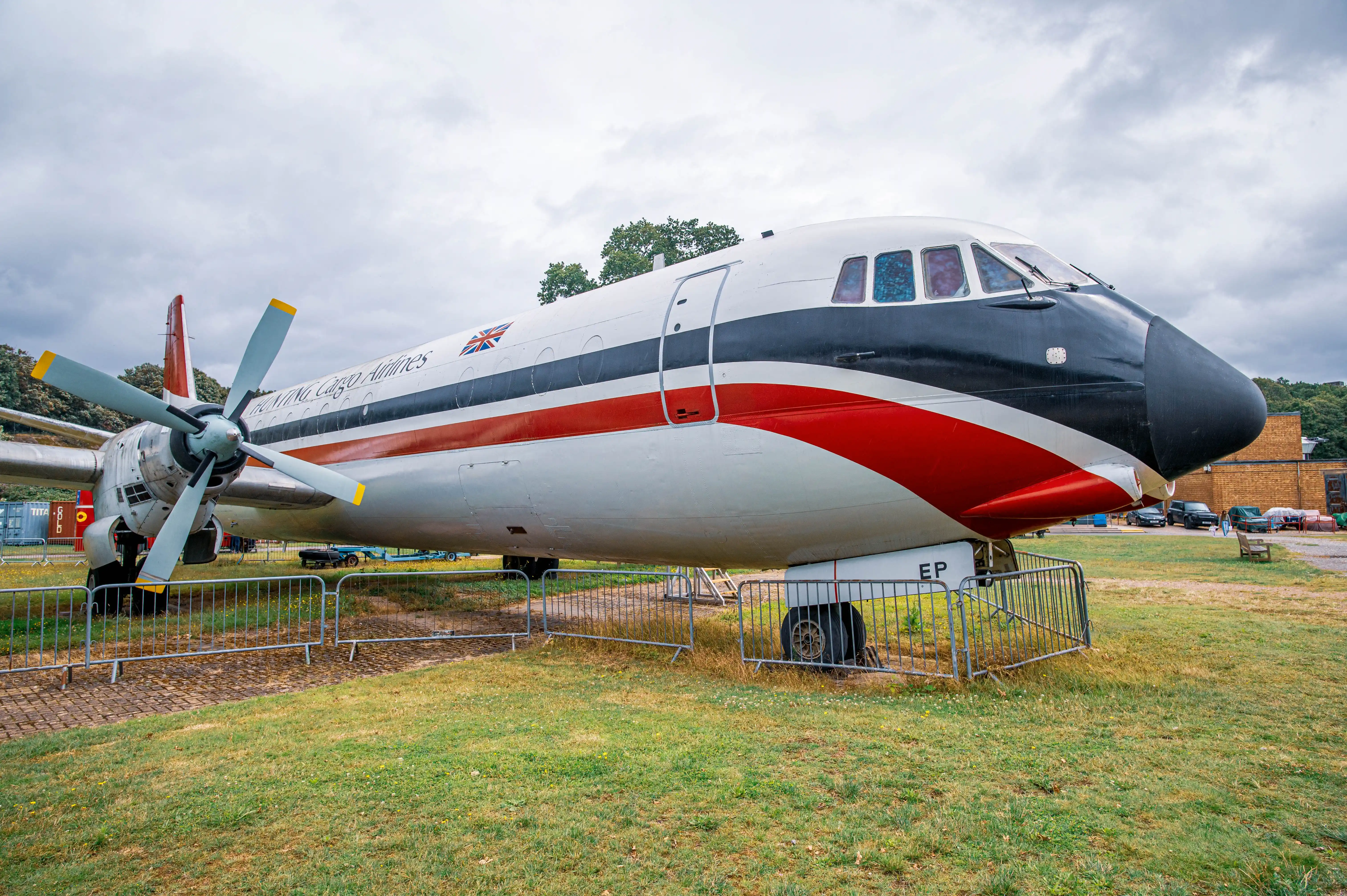 A vintage propellor aircraft with the text Hunting Cargo Airlines and a Union Jack flag on its side, displayed outdoors on a cloudy day.