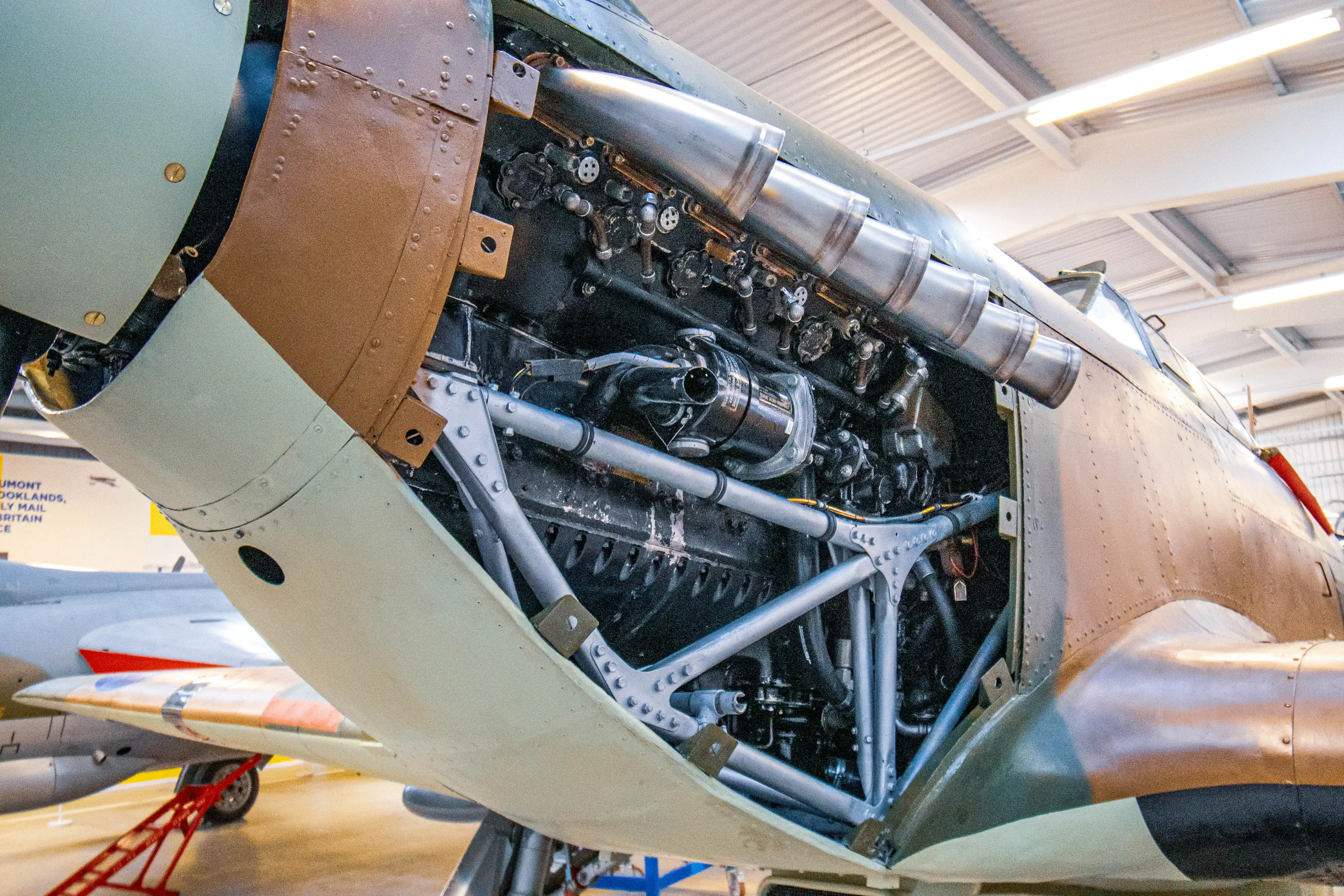 A detailed shot of the engine of a Hawker Hurricane aircraft, with panels removed to reveal the internal workings.