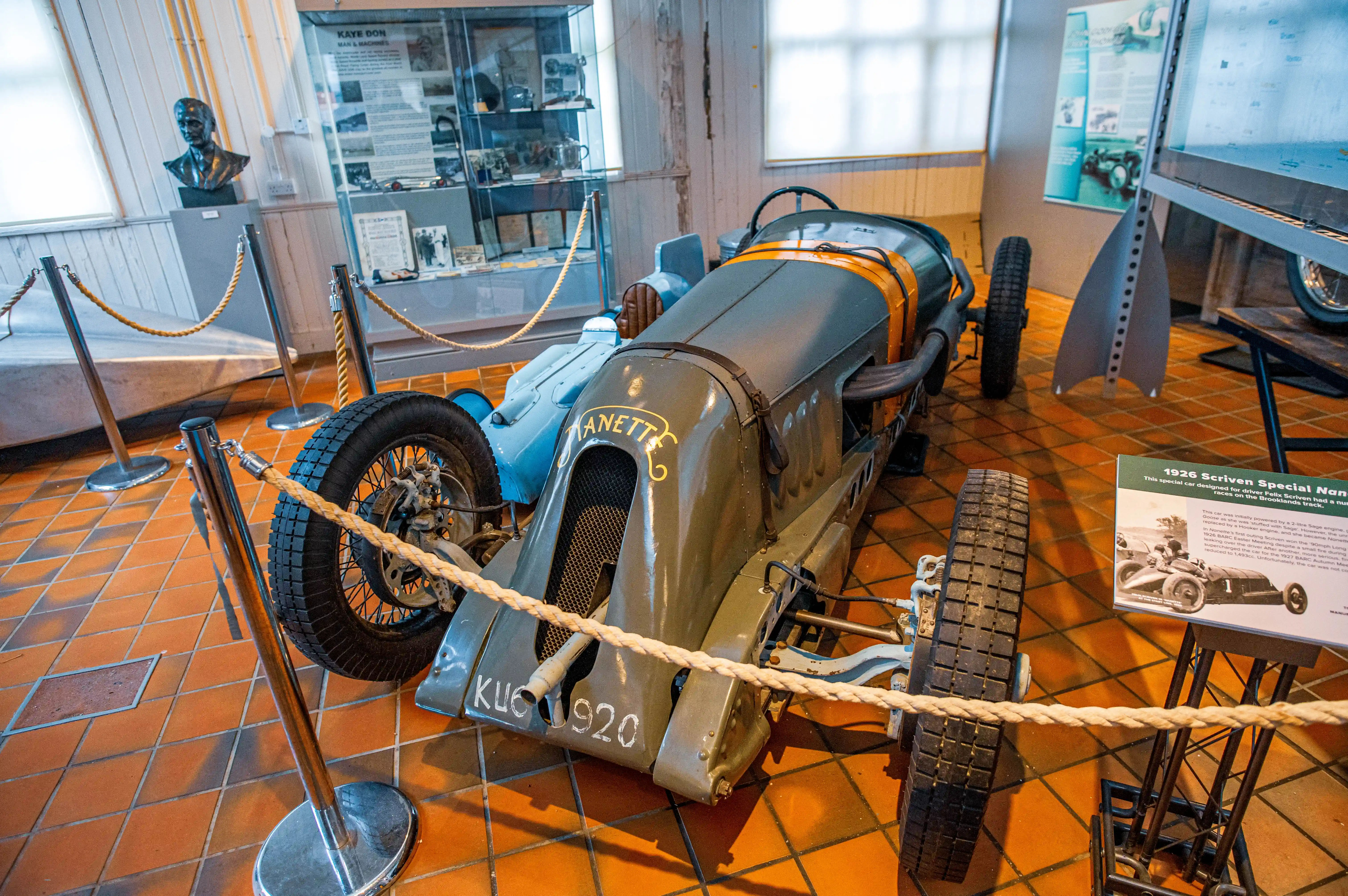 A vintage grey and blue racing car with orange accents, featuring the text 