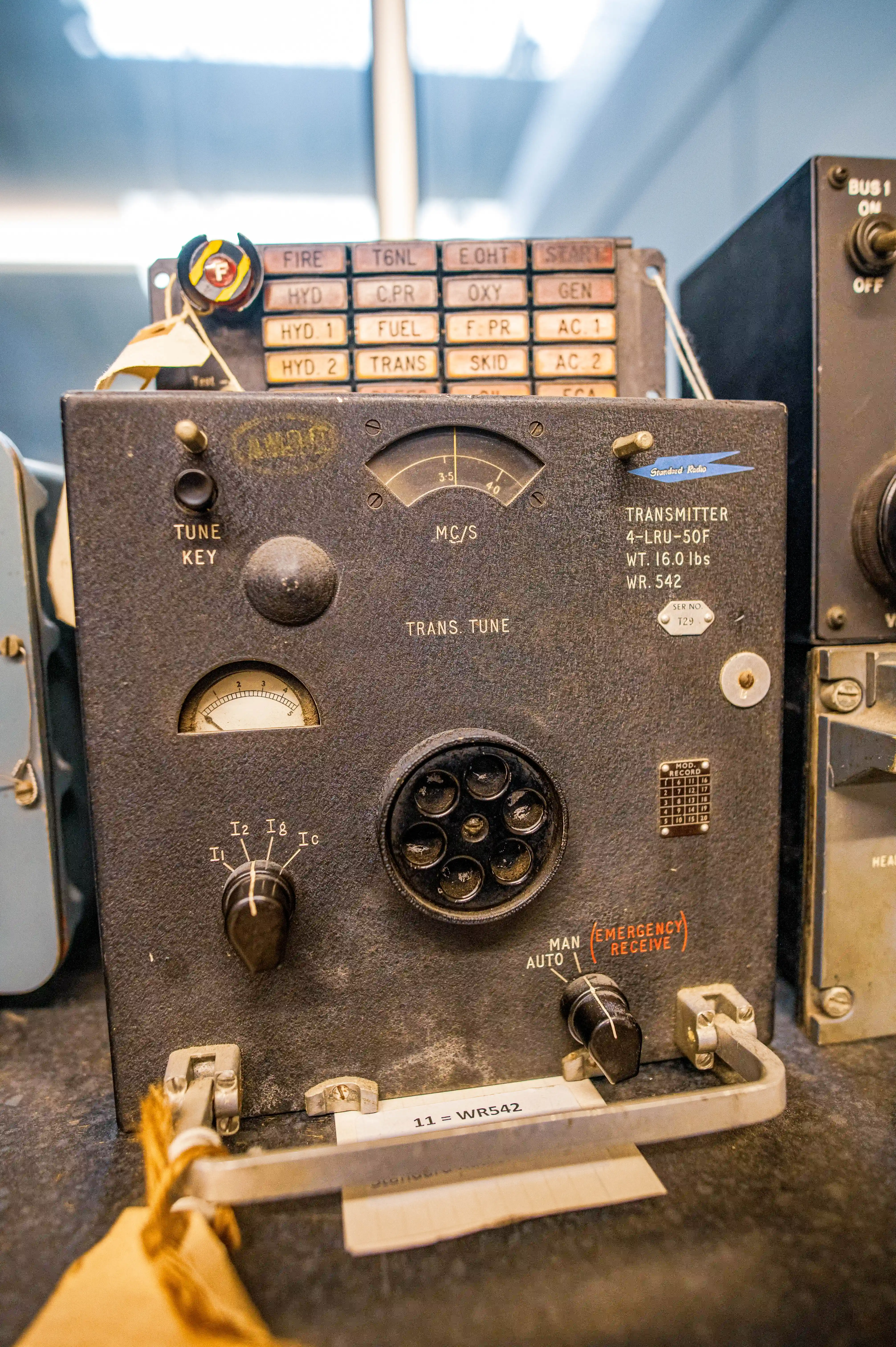 A vintage grey aviation control box with numerous circular, multi-pin connectors in different colours, a yellow knob labelled PRESSURE SUPPLY, and handwritten modifications.