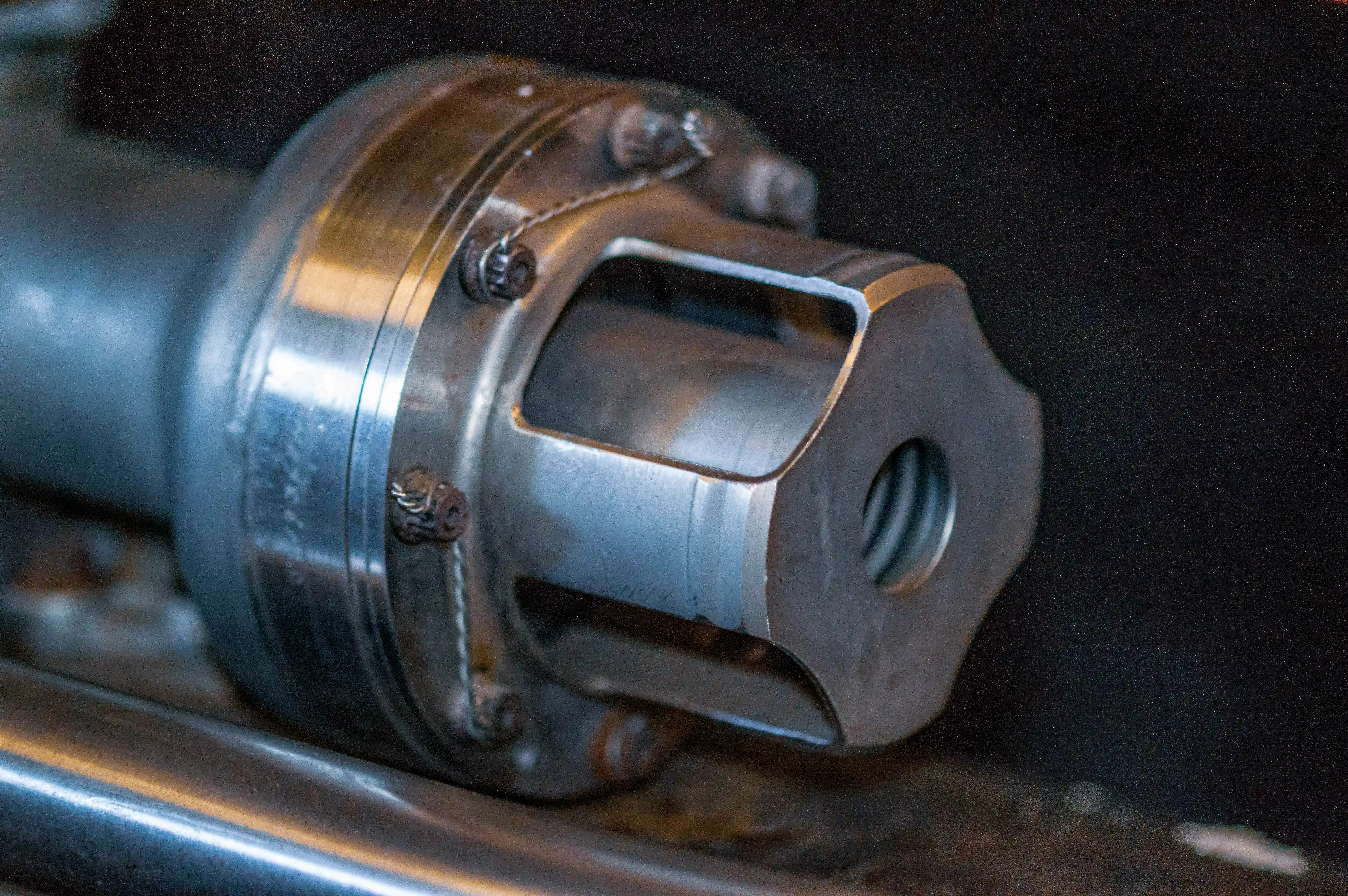 A detailed close-up of an engine casing, showcasing its metallic surface, bolt fastenings, and precision engineering. The casing features visible bolts, seams, and a polished metal finish