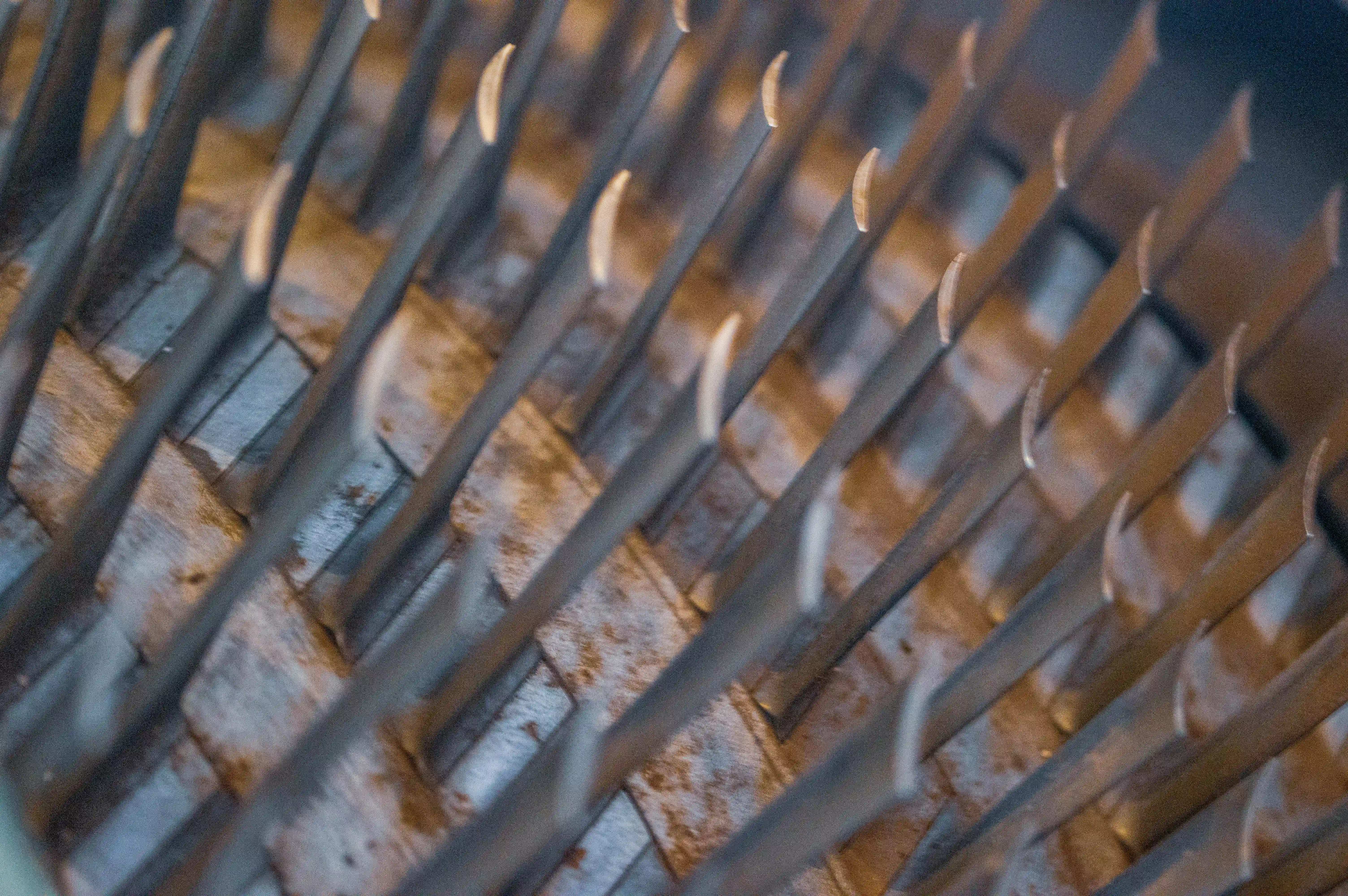 A macro view of turbine blades, showcasing their aerodynamic design, metallic finish, and intricate craftsmanship. The blades are arranged in a radial pattern, with light reflecting off their polished surfaces