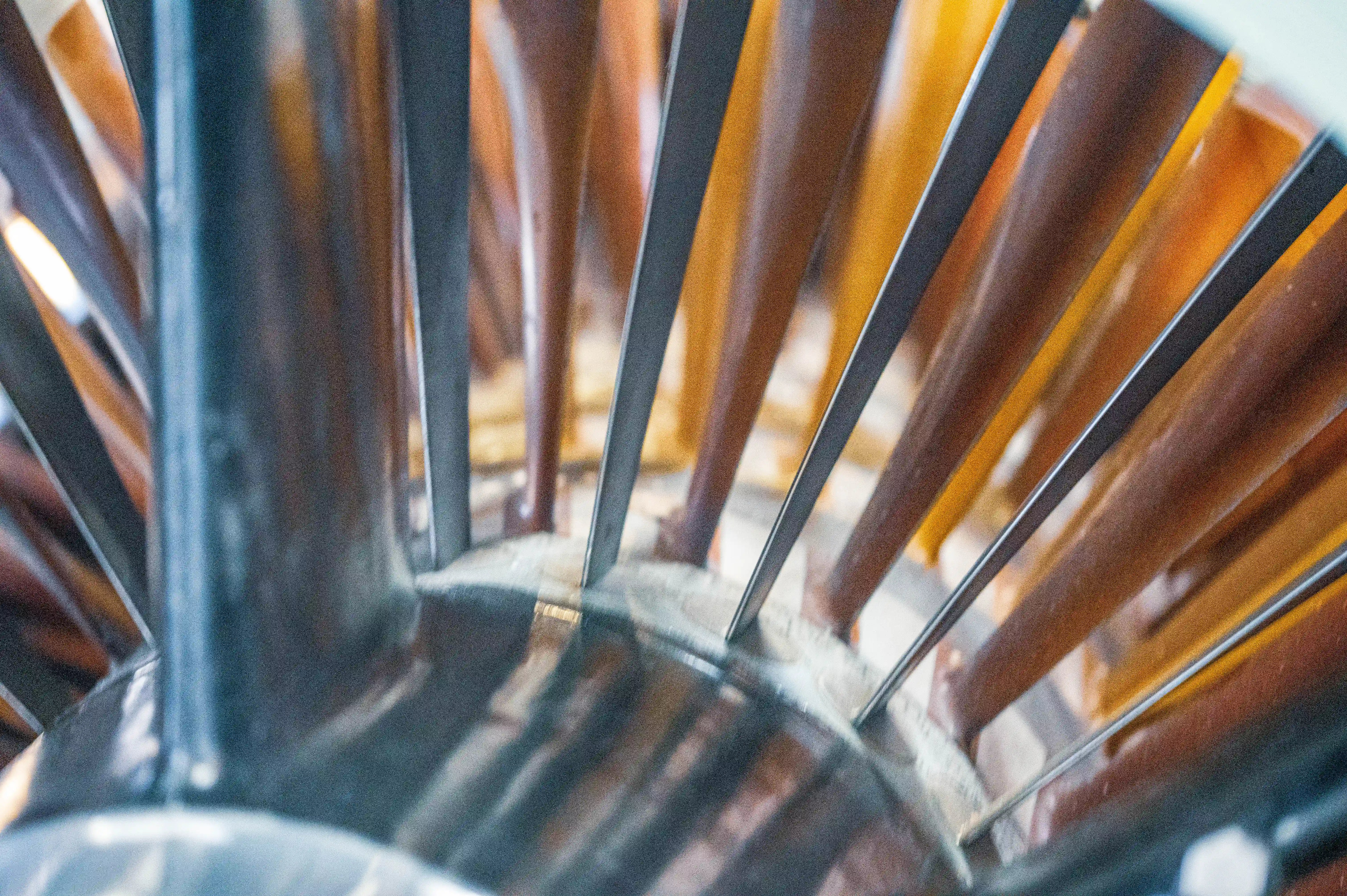  Close-up shot of the fan blades of a jet engine, showing the metallic grey central hub and numerous curved blades that fan out.