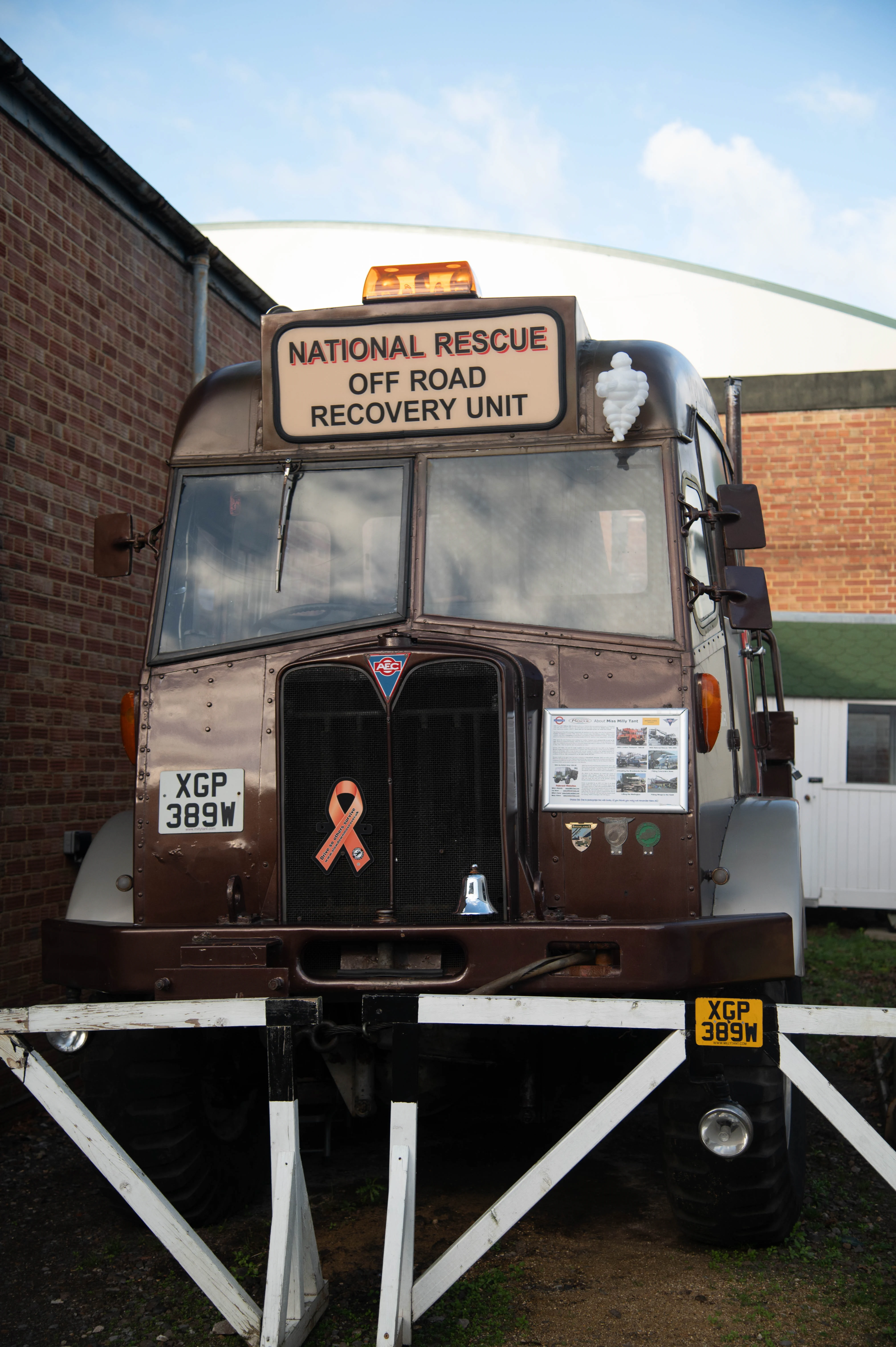 Front view of a vintage off-road rescue vehicle with roof sign, grille badges and an information board.