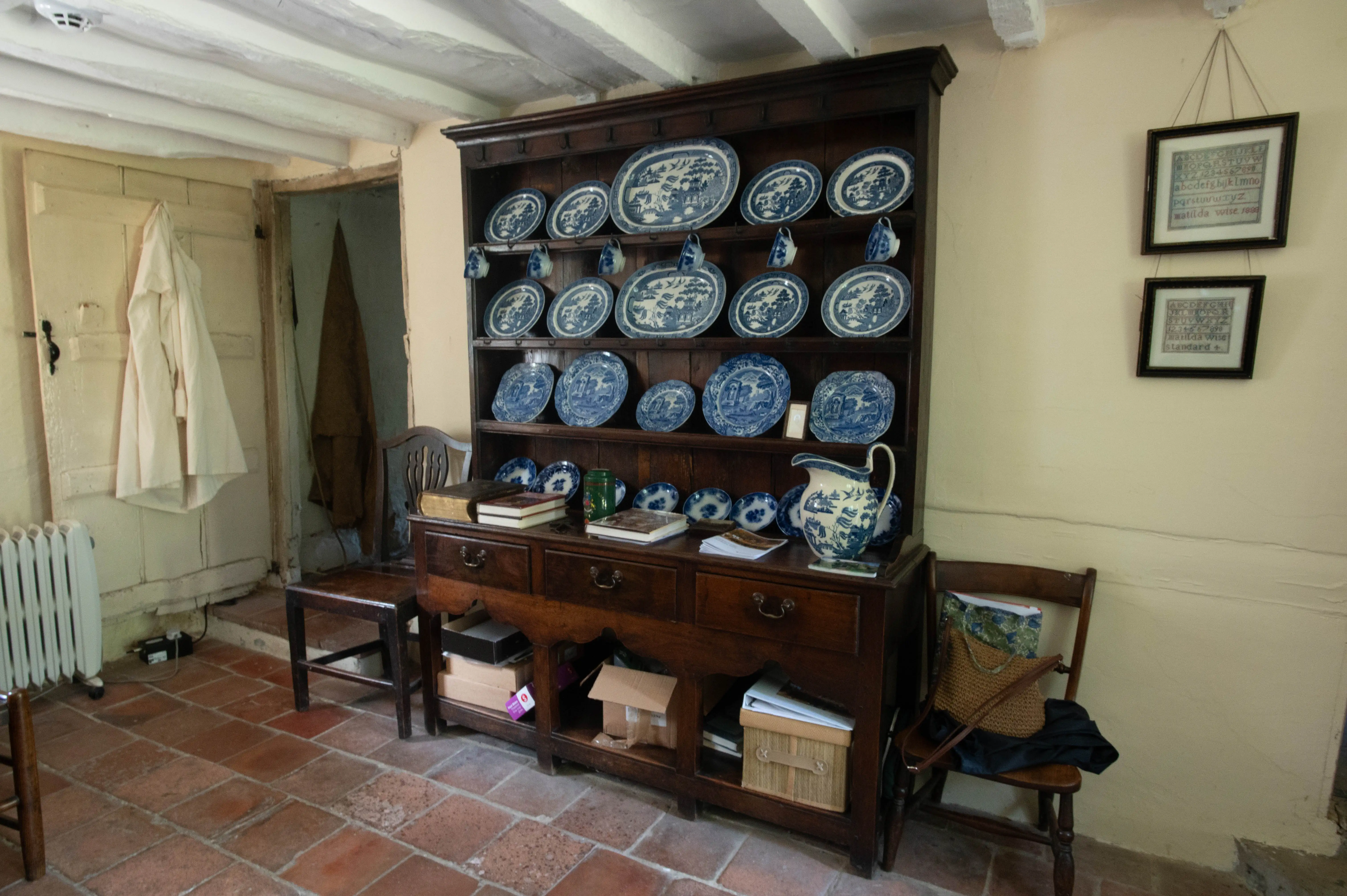 A rustic room with a large wooden dresser displaying blue and white china.