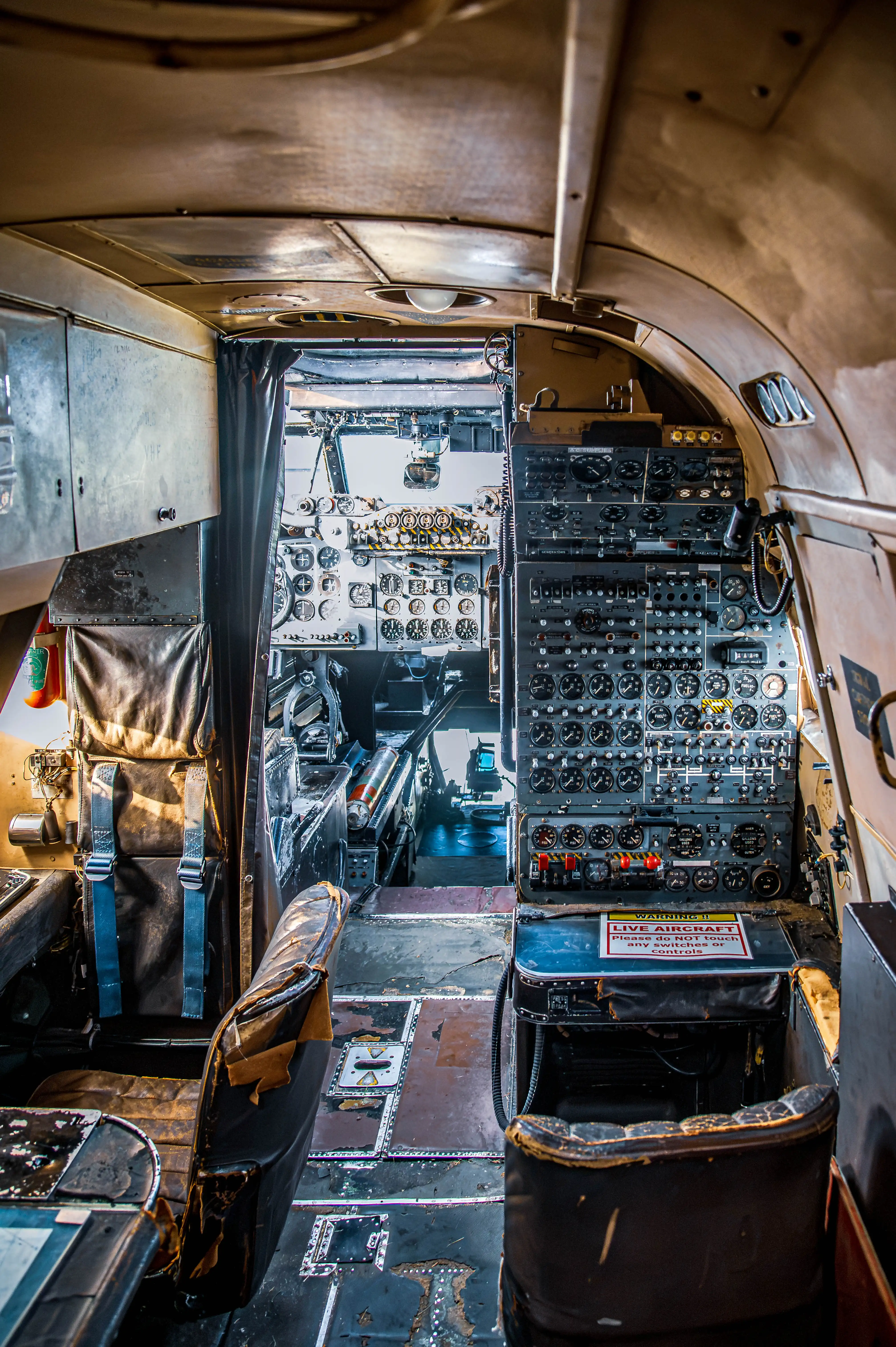 View inside the cockpit of an old aeroplane, highlighting the densely packed dashboard with numerous analogue gauges and levers.