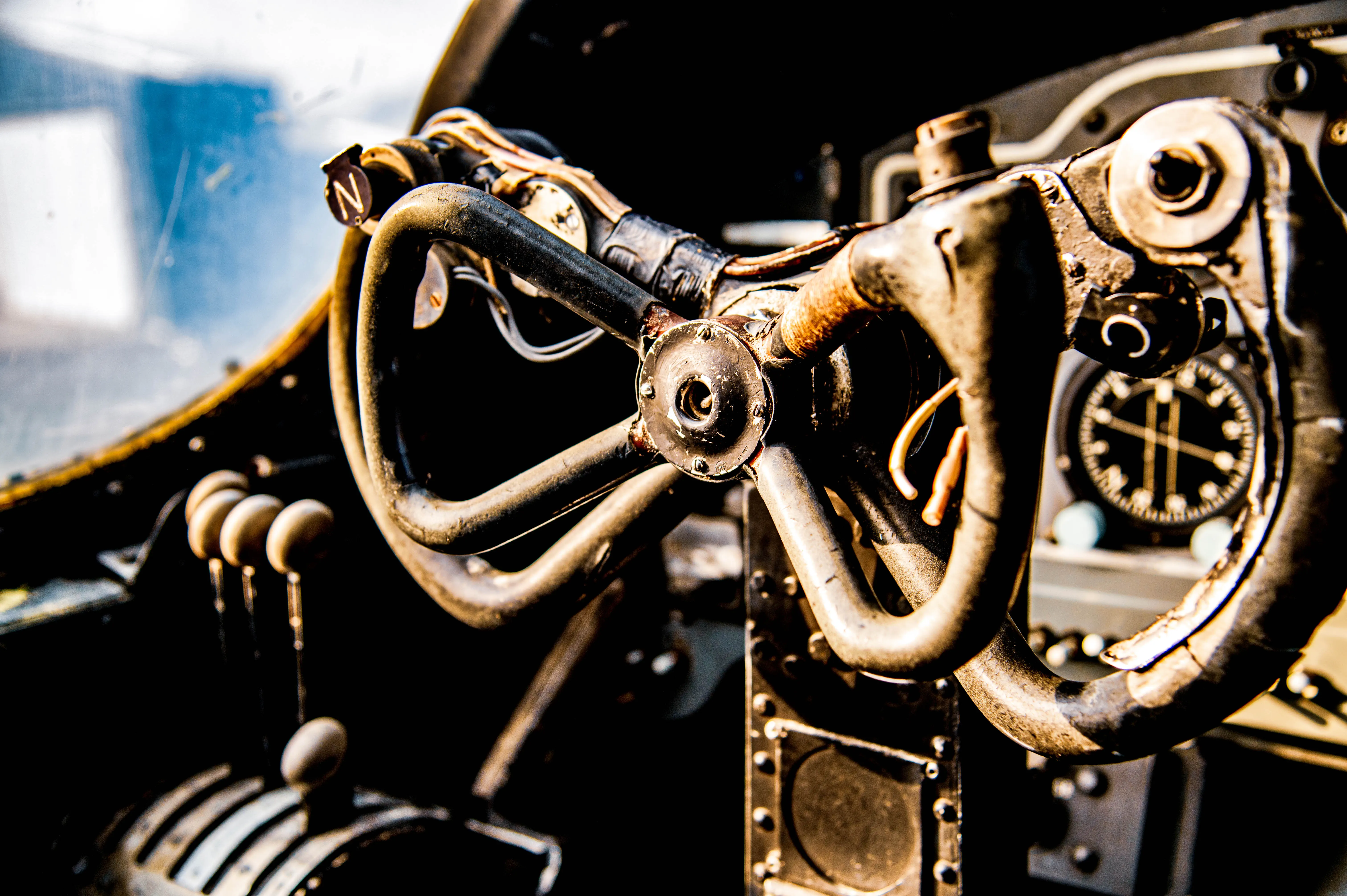 A front-on view of an old, grey aeroplane's nose and cockpit, with large windows and visible mechanical components.