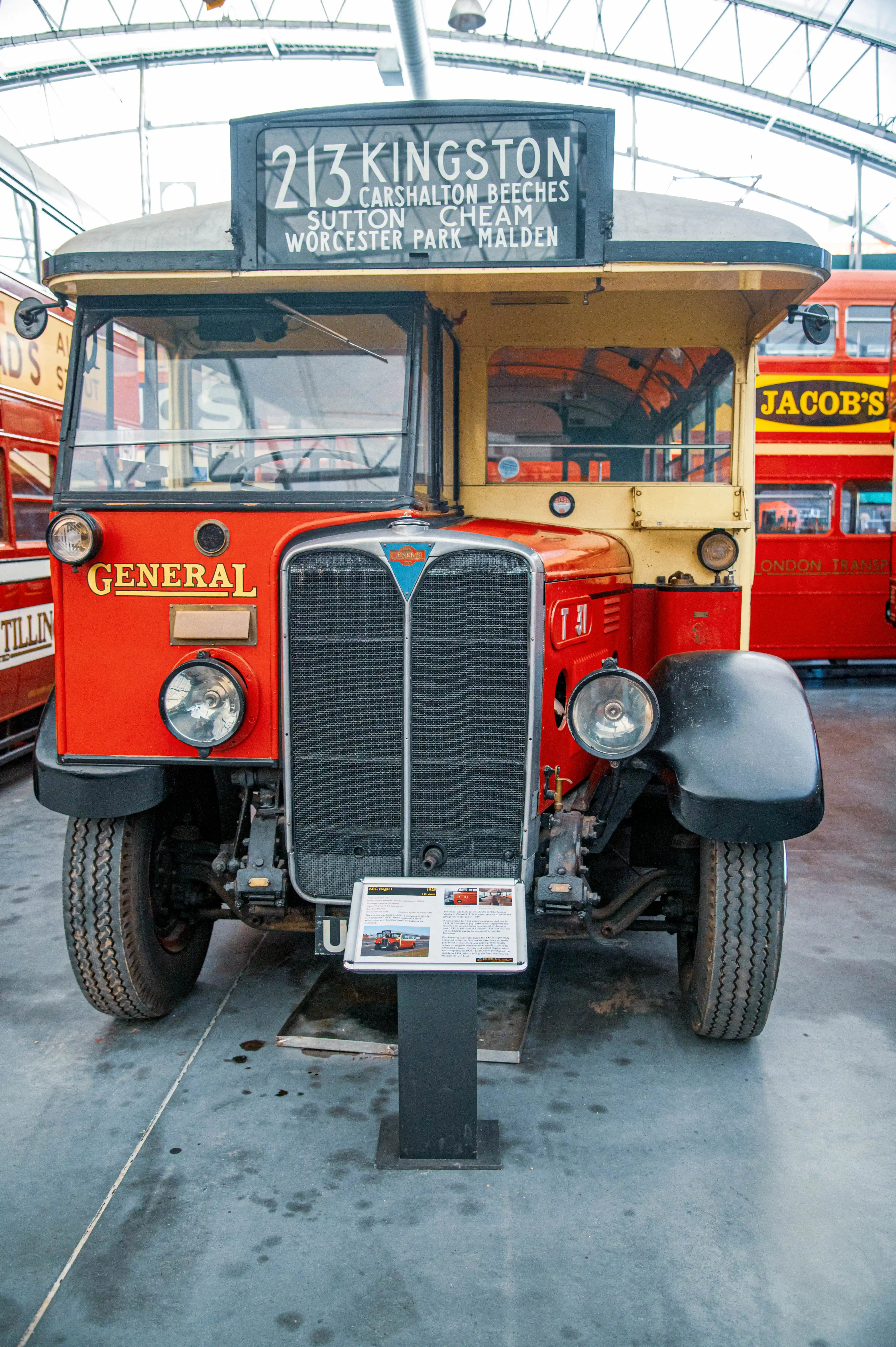 Front view of a vintage red and yellow AEC Regent bus with a detailed destination board.