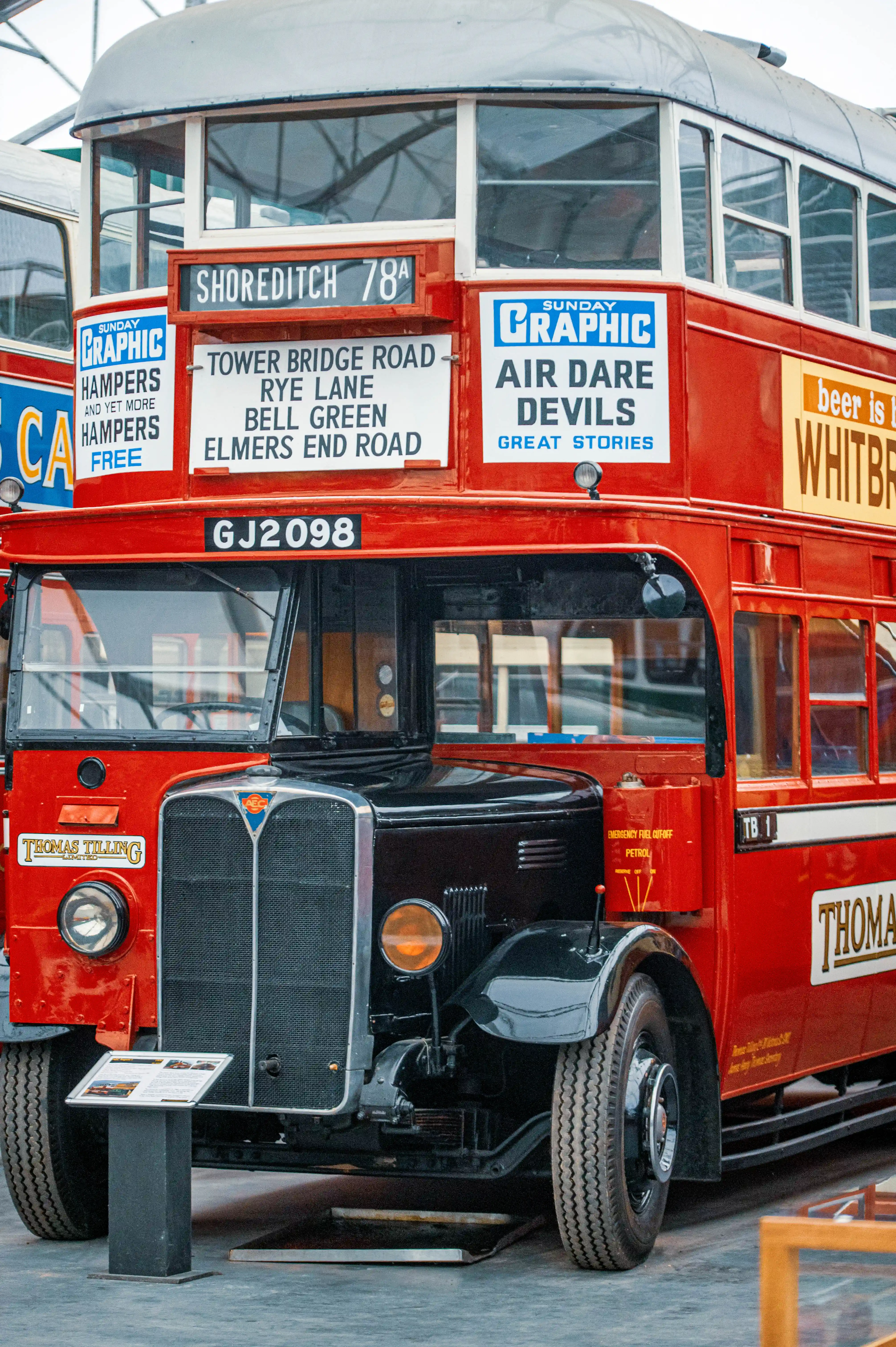 Front view of a classic red double-decker bus with signs indicating route numbers and destinations such as Shoreditch 78A and Tower Bridge Road
