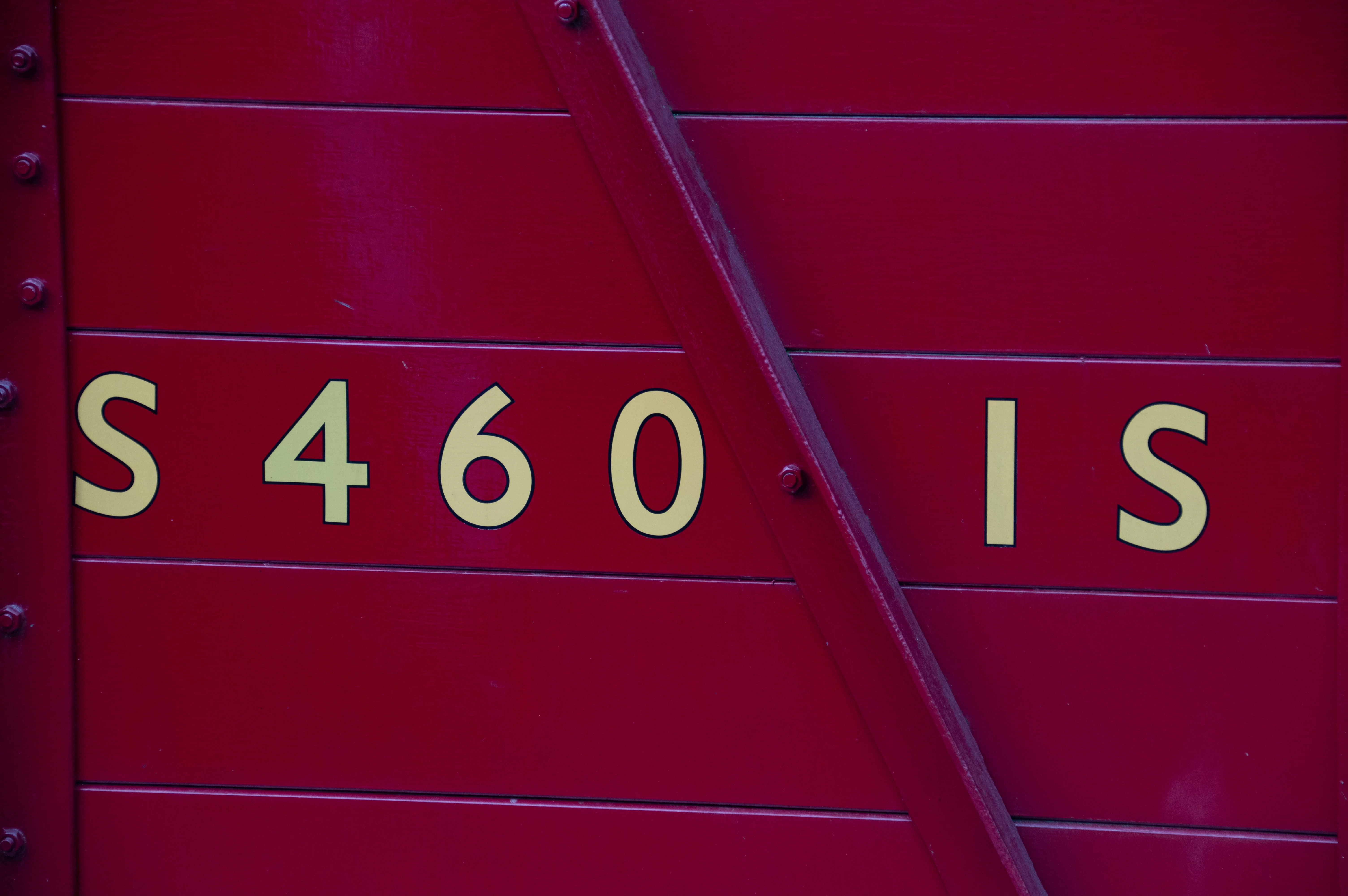 Close-up of a red train carriage showing the letters and numbers 