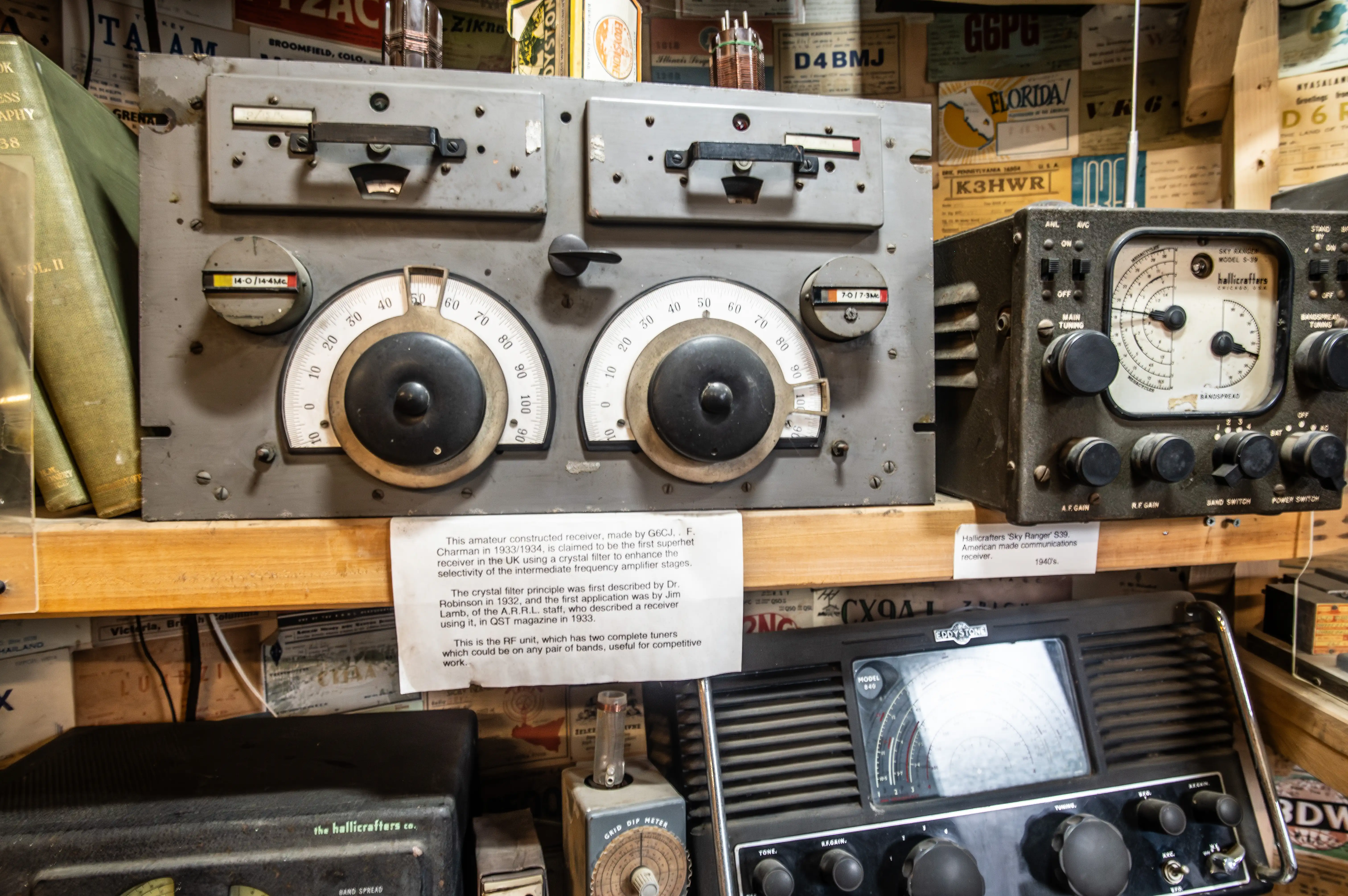 Display of early radio receivers including a 1933/34 amateur-built superhet and a Hallicrafters Sky Ranger S-39 with labels and background call signs.