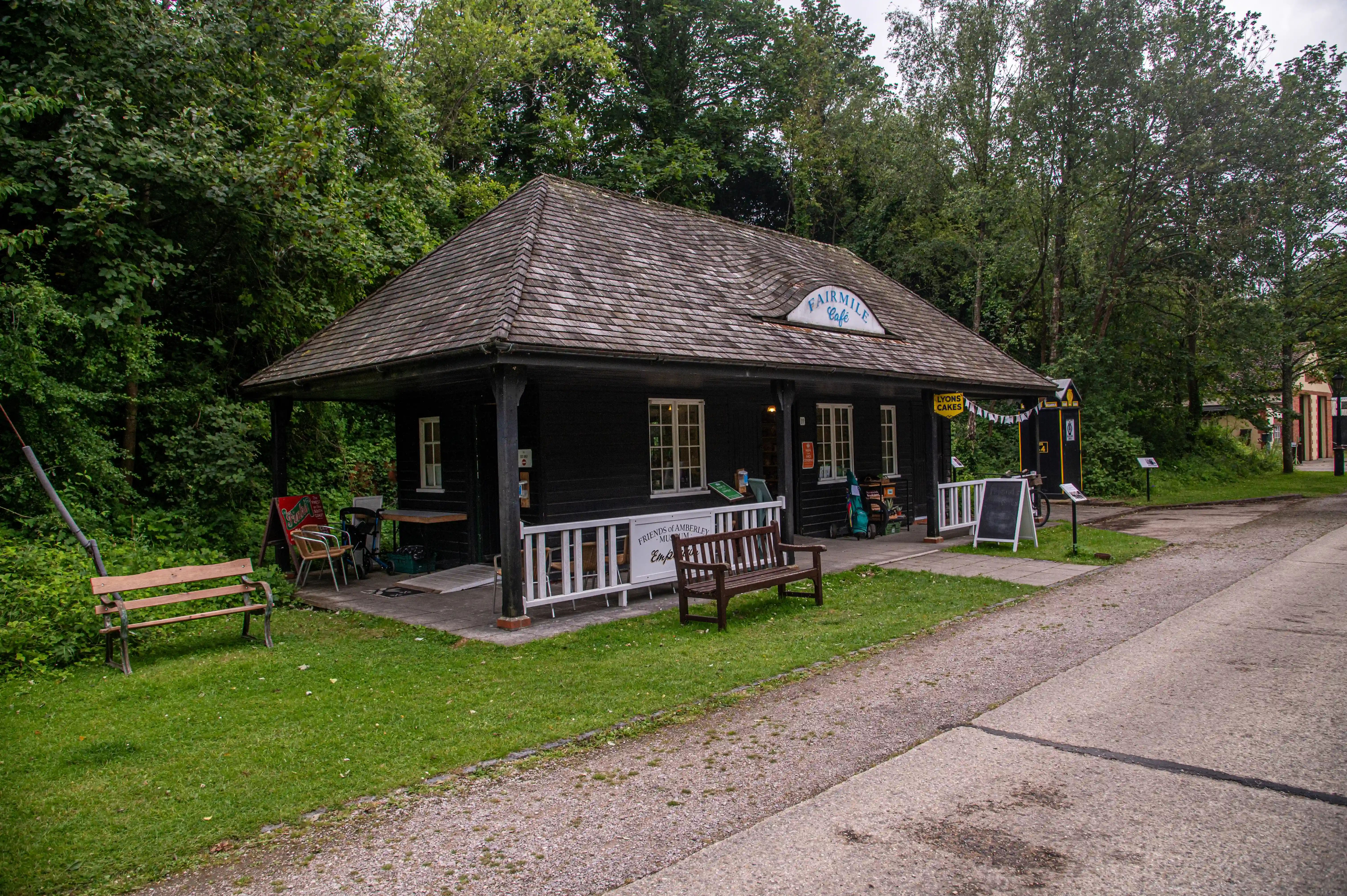 A dark wooden cafe building with a shingled roof, named 