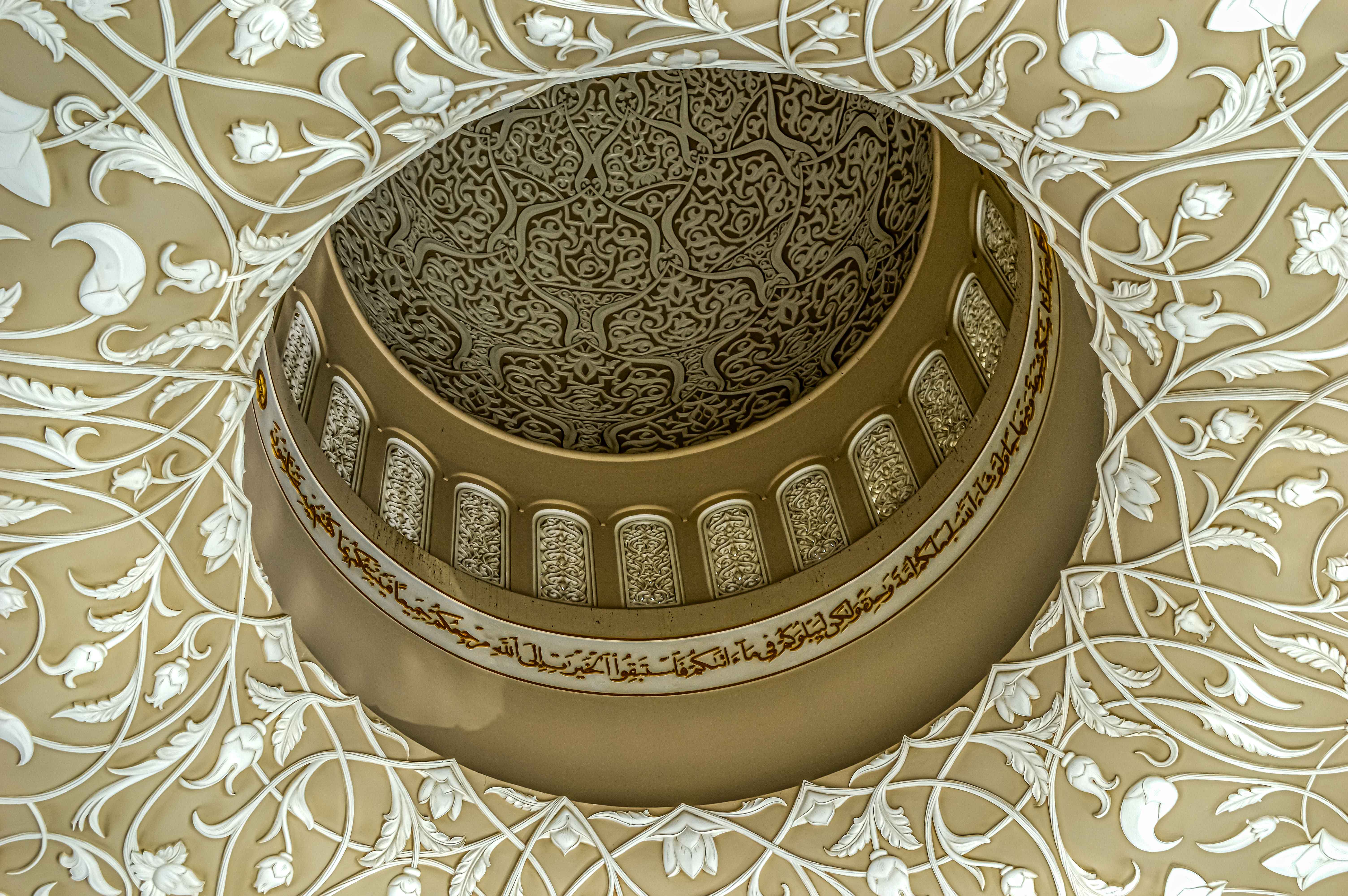 an intricately designed ceiling with elaborate patterns and Arabic calligraphy