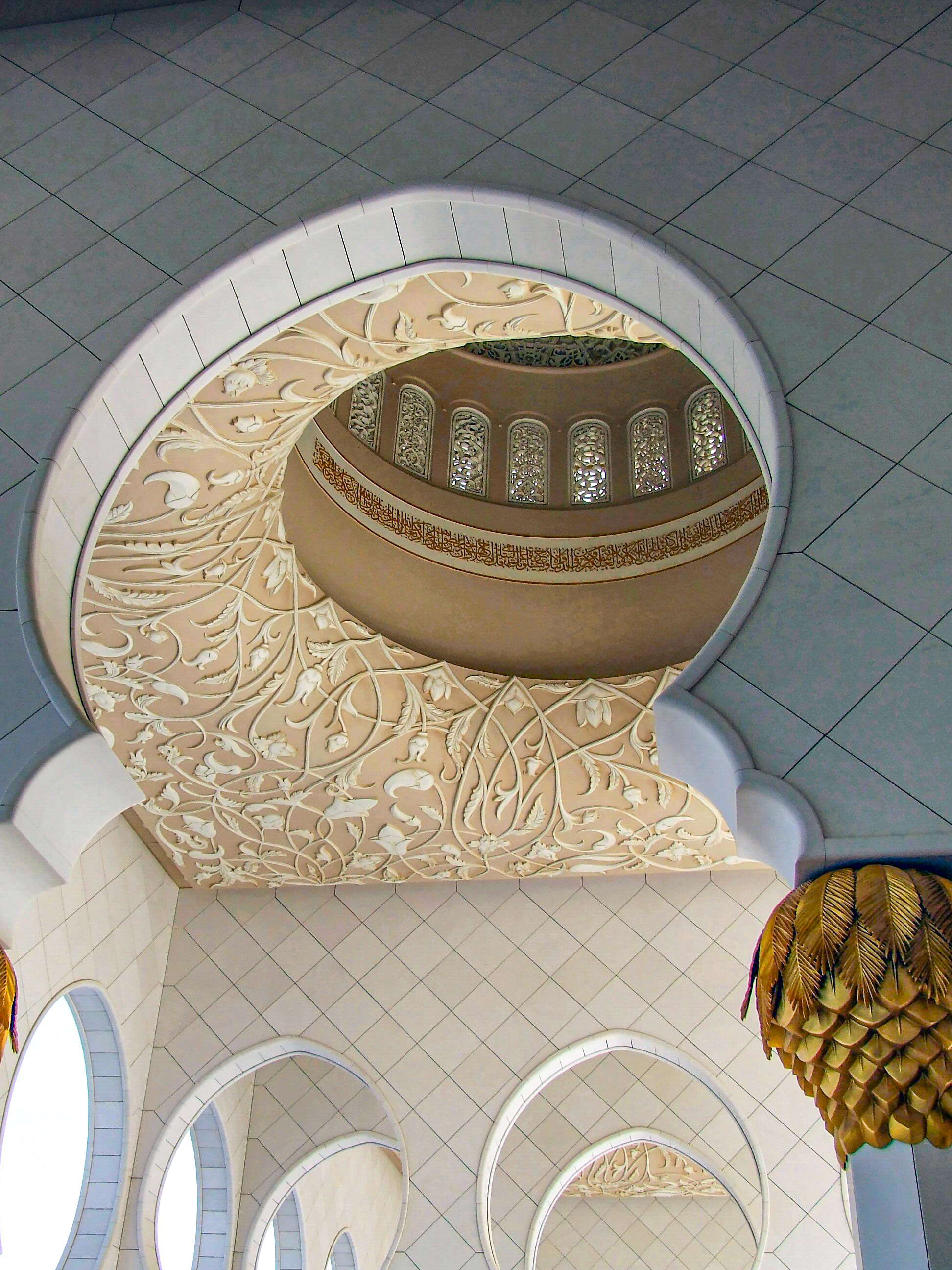 ornate carvings and calligraphy within a circular frame on a tiled ceiling