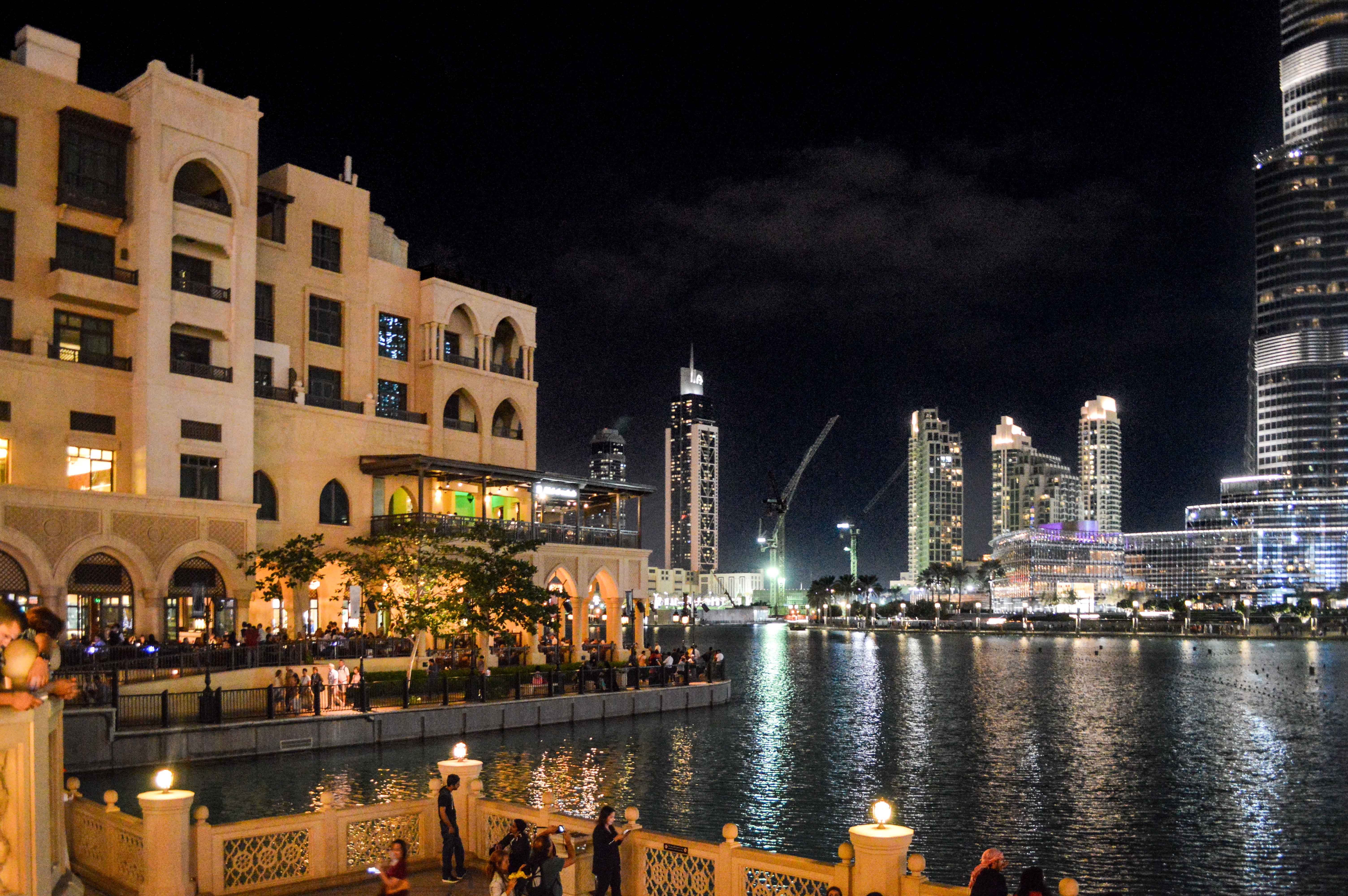 a nighttime scene of a modern waterfront area with a blend of traditional and contemporary architecture